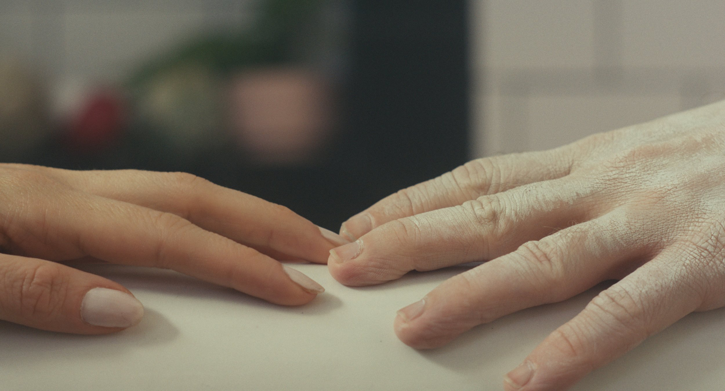 Still from the short film "Achiever," two hands touch